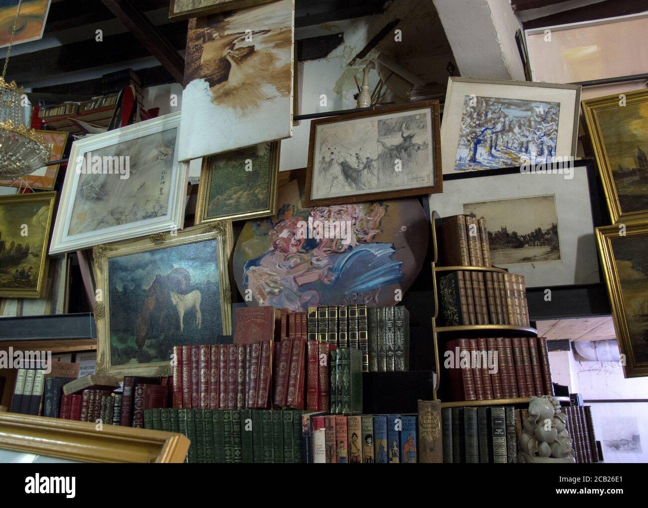 Ancienne boutique de livres à main levée avec des images et des peintures accrochées au mur Banque D'Images