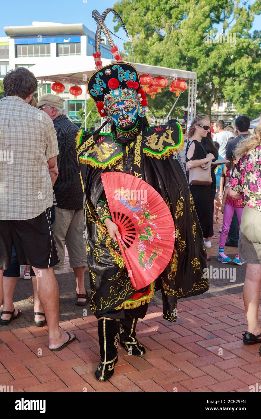 Un artiste chinois du « visage changeant » (lian bien) en masque et robe dragon noire lors des célébrations du nouvel an chinois. Hamilton (Nouvelle-Zélande), 2/16/2019 Banque D'Images
