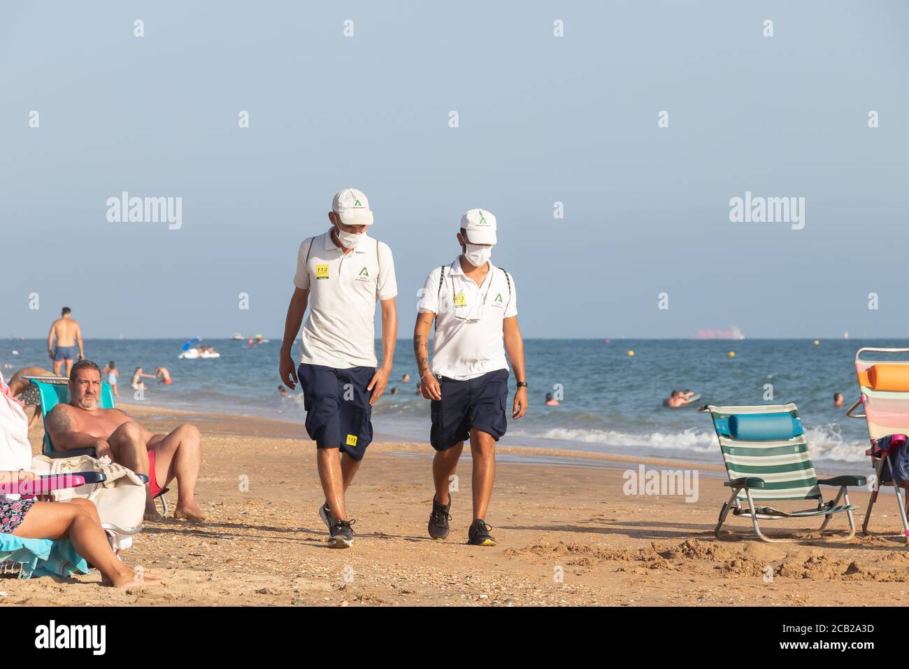 Punta Umbria, Huelva, Espagne - 7 août 2020: La garde de plage de Junta de Andalucia contrôle la distance sociale et l'utilisation du masque de protection Banque D'Images