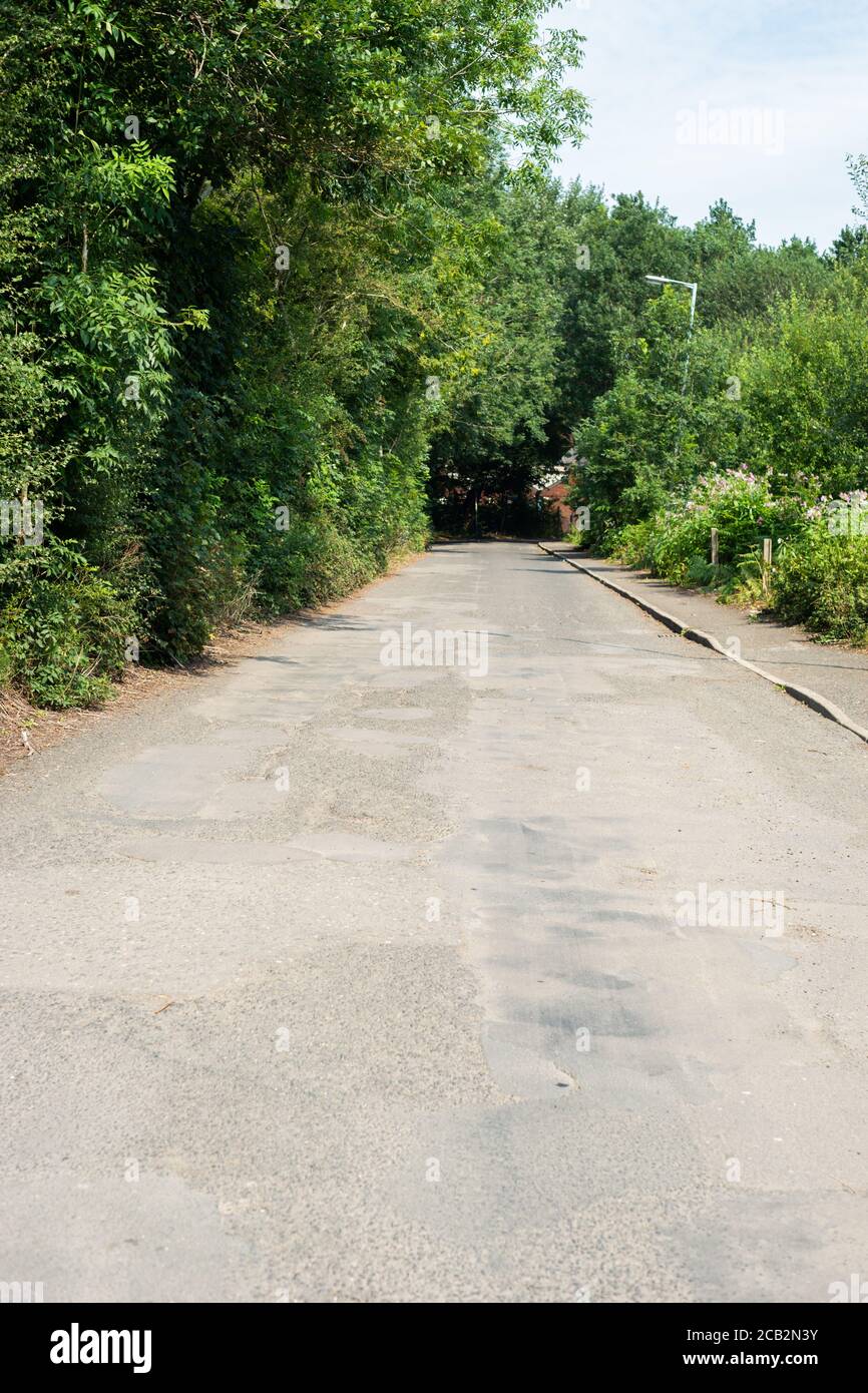 Exemple de route mal réparée au Royaume-Uni avec des nids-de-poule et une surface de route inégale. Mount Sion Road / Sion Street, Radcliffe, Manchester, Royaume-Uni Banque D'Images