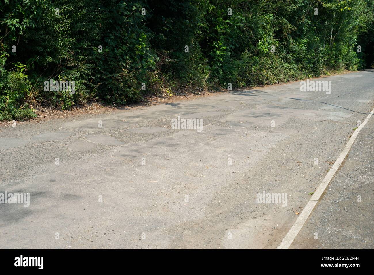 Exemple de route mal réparée au Royaume-Uni avec des nids-de-poule et une surface de route inégale. Mount Sion Road / Sion Street, Radcliffe, Manchester, Royaume-Uni Banque D'Images
