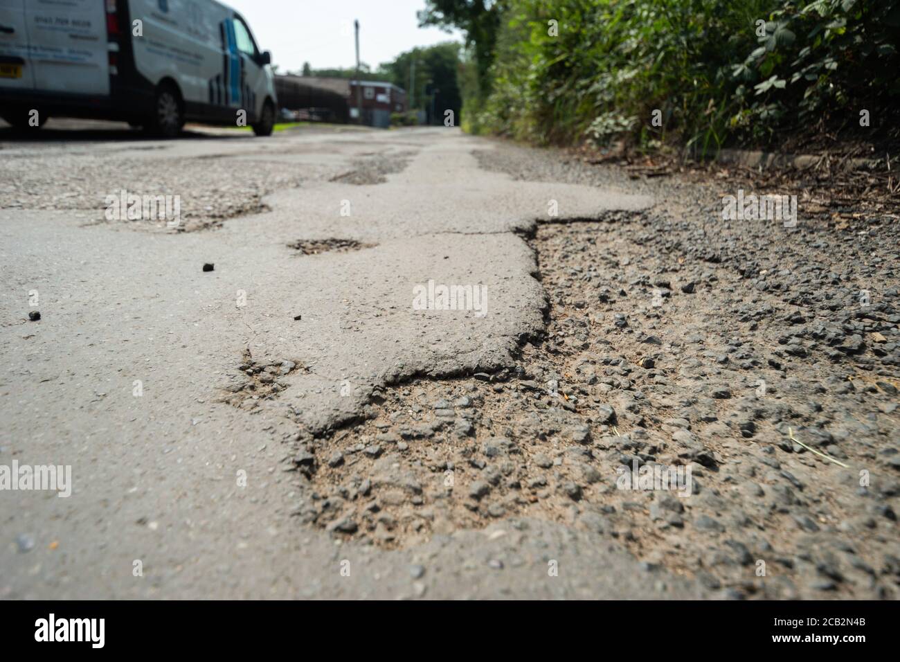 Exemple de route mal réparée au Royaume-Uni avec des nids-de-poule et une surface de route inégale. Mount Sion Road / Sion Street, Radcliffe, Manchester, Royaume-Uni Banque D'Images