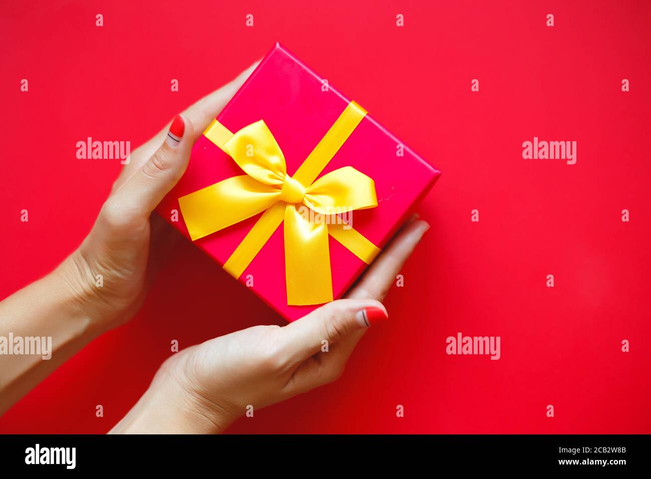les mains des femmes avec une belle manucure tiennent une boîte cadeau Banque D'Images