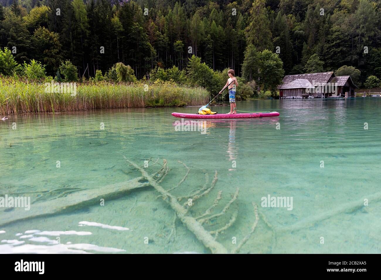Young boy sur paddleboard sur le lac Banque D'Images