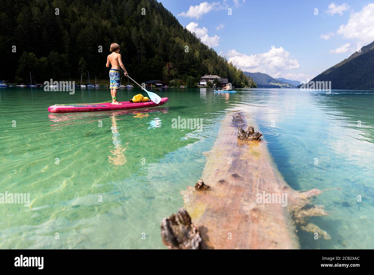 Young boy sur paddleboard sur le lac Banque D'Images