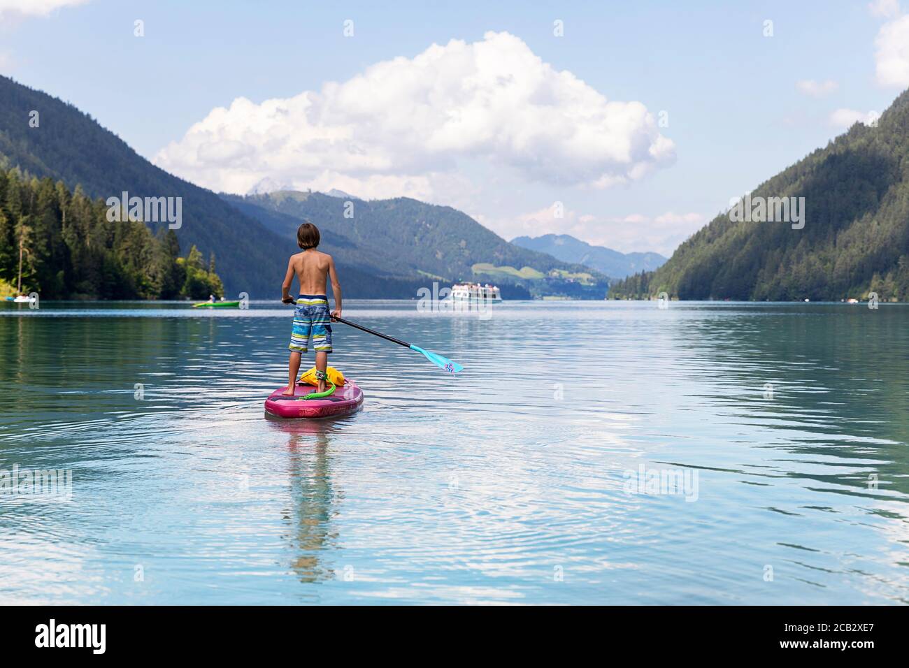 Young boy sur paddleboard sur le lac Banque D'Images