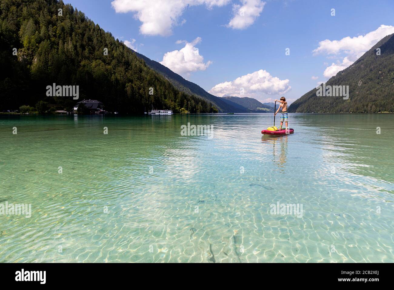 Young boy sur paddleboard sur le lac Banque D'Images