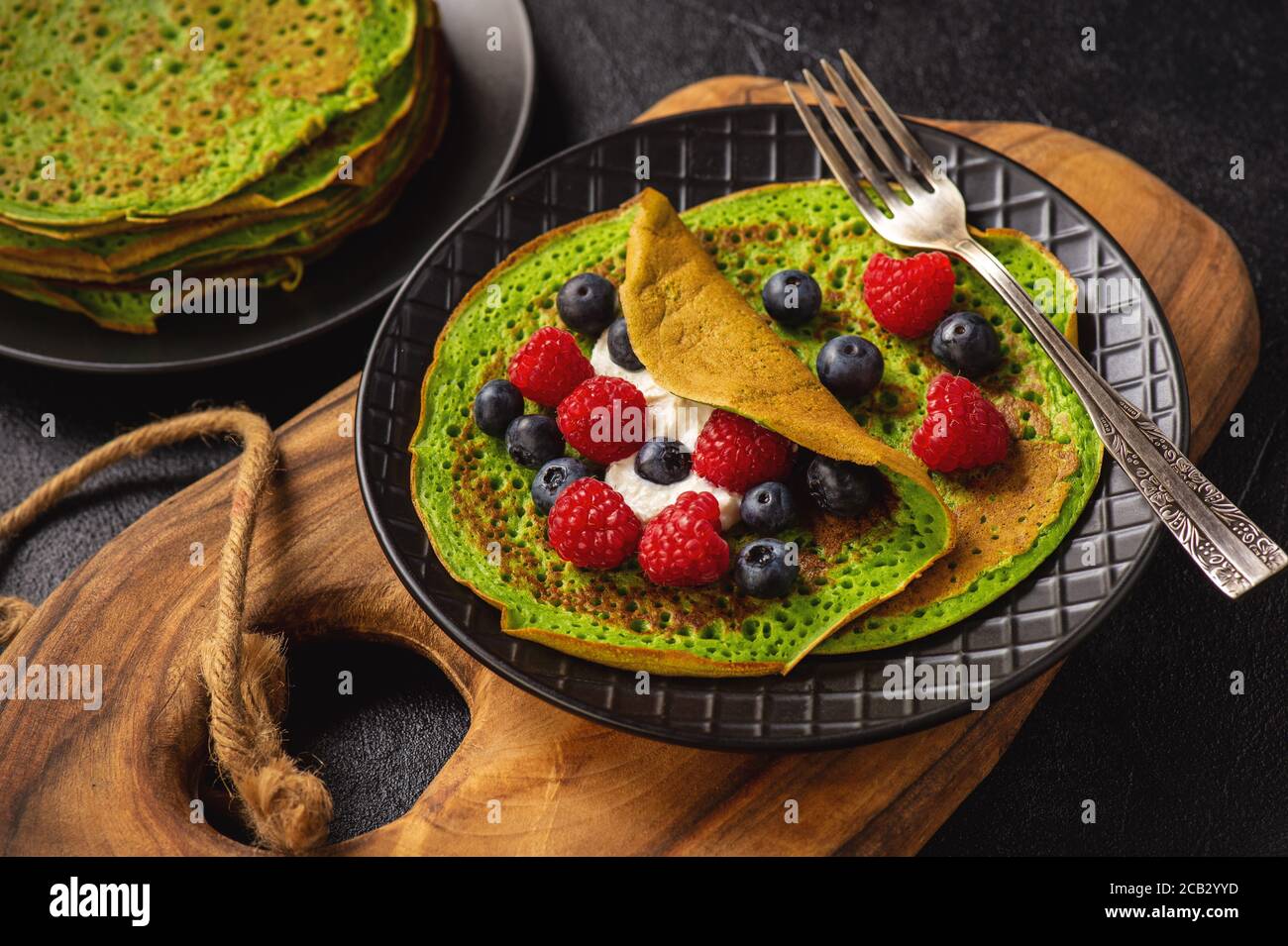 Crêpes d'épinards au fromage, framboises et bleuets. Banque D'Images