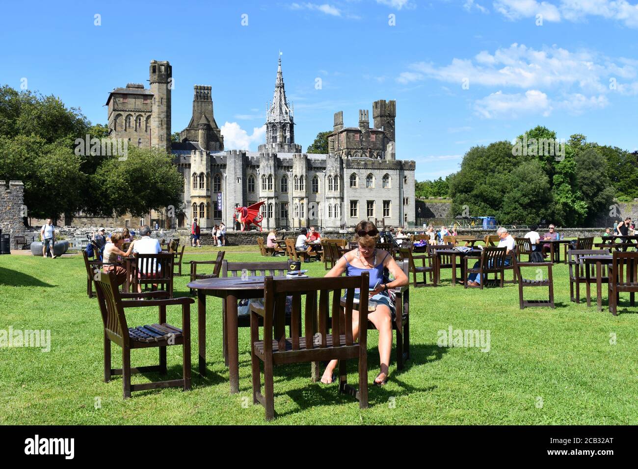 Les gens qui profitent du soleil et qui ont un verre aux tables socialement distancées du château de Cardiff, Cardiff, pays de Galles Banque D'Images