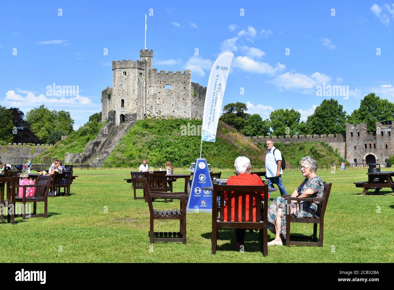 Les gens qui profitent du soleil et qui ont un verre aux tables socialement distancées du château de Cardiff, Cardiff, pays de Galles Banque D'Images