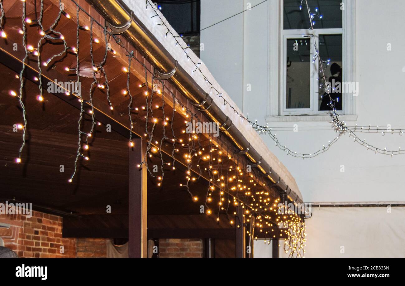 Décoration de Noël de bâtiments, guirlandes avec des ampoules sur la façade  et le toit du marché de rue contre le ciel sombre de nuit, vacances d'hiver  se Photo Stock - Alamy