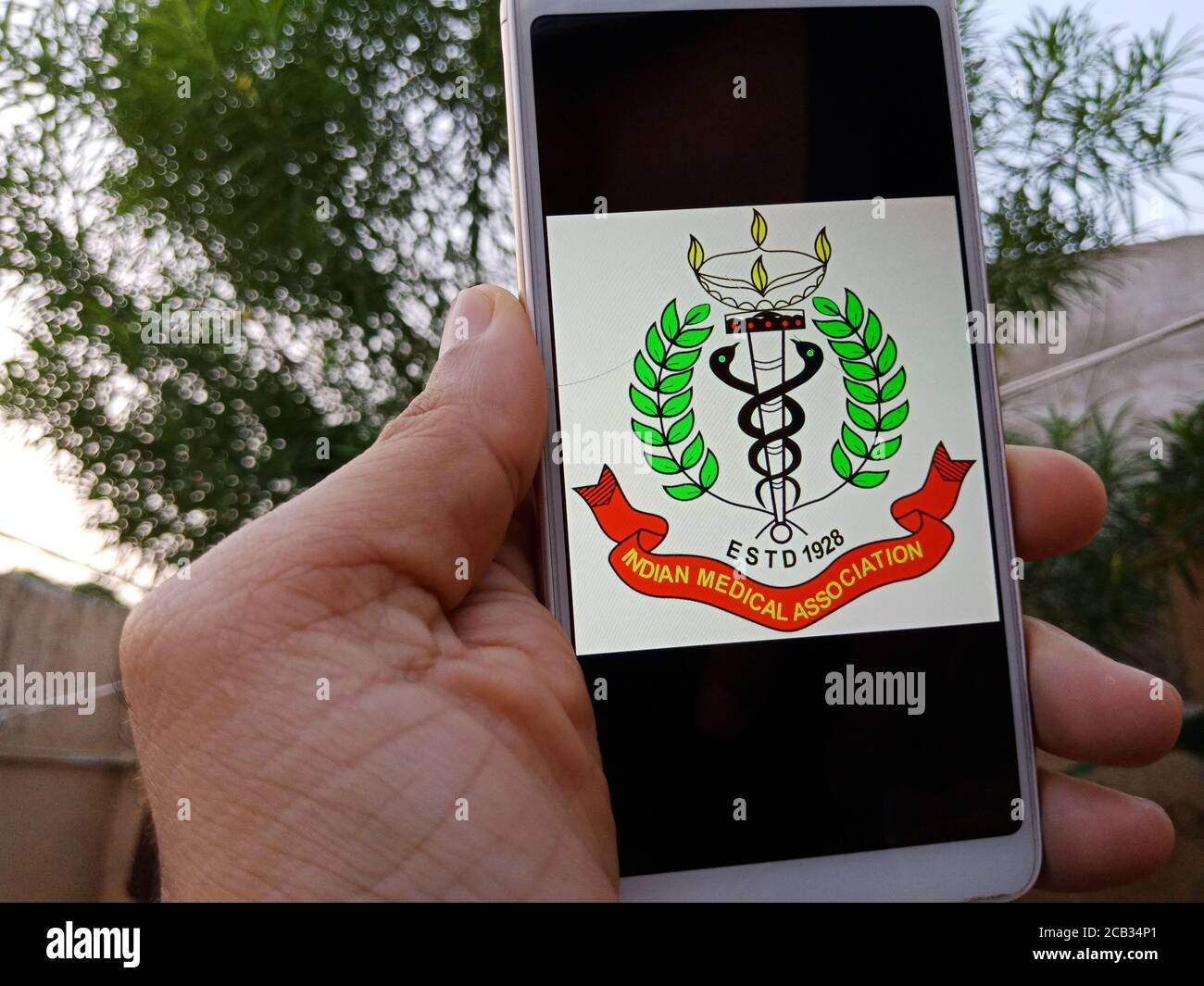 DISTRICT KATNI, INDE - 23 MAI 2020: Femme tenant un smartphone avec le logo de l'association médicale indienne affiché à l'écran. Gouvernement indien par Banque D'Images