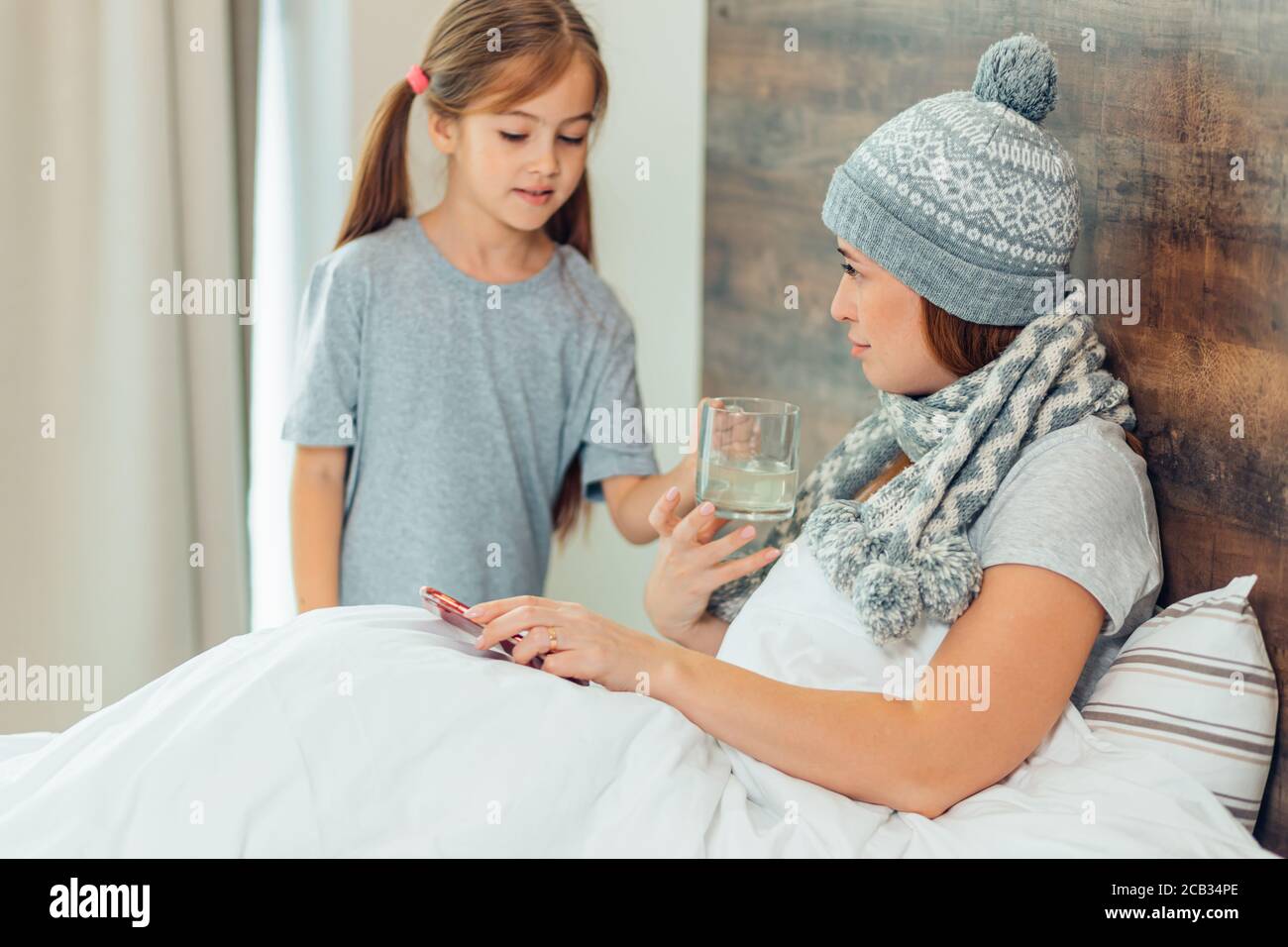 l'enfant génial se soucie de la maladie de la mère malade, de l'aide à l'enfant et de l'attention accordée à la mère couché sur le lit Banque D'Images