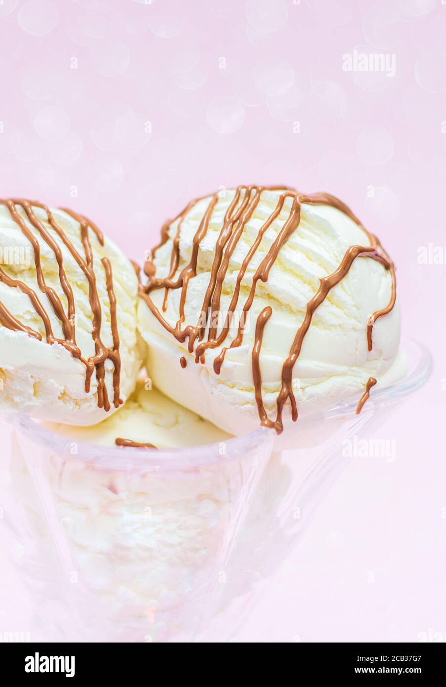 Boules de crème glacée au chocolat sur fond rose avec bokeh. Meilleur dessert en été Banque D'Images