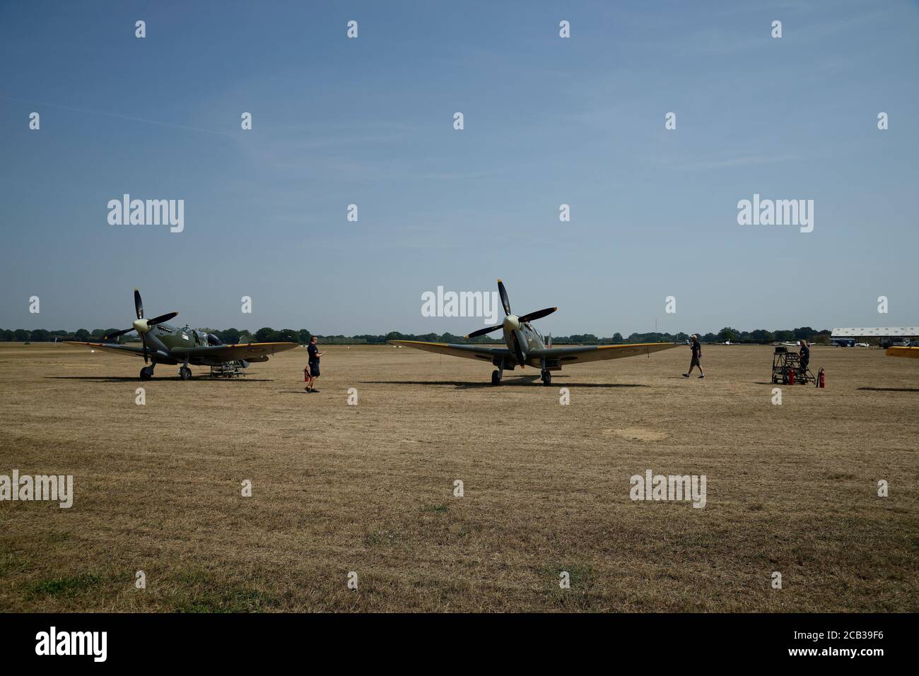 Un avion Spitfire a atterri sur l'aérodrome de Headcorn à Kent, dans le sud-est de l'Angleterre, au Royaume-Uni, et l'équipage au sol s'approche. Banque D'Images