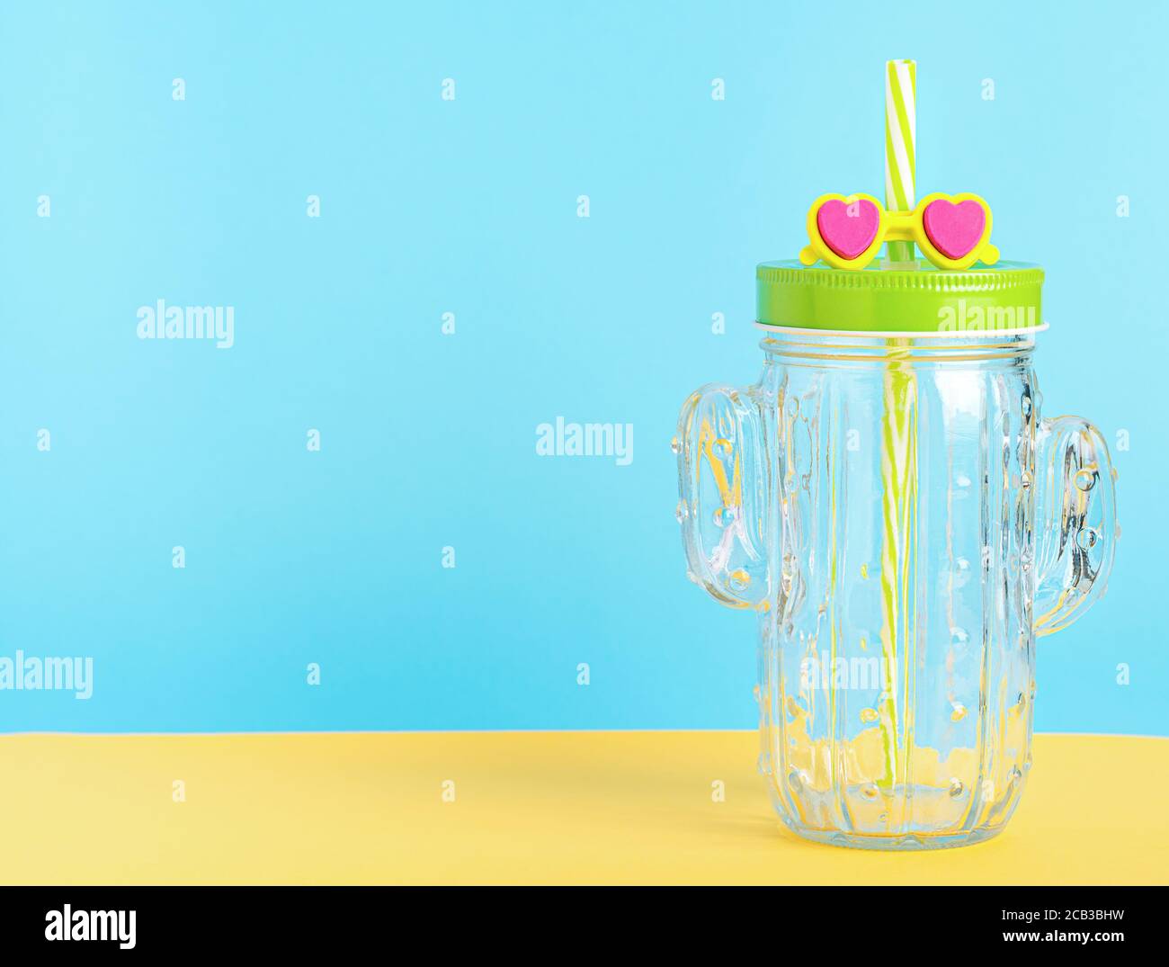 Pot de maçon en forme de cactus avec couvercle vert et paille avec lunettes de soleil lovyle. Banque D'Images Pot de maçon en forme de cactus avec couvercle vert et paille avec lunettes de soleil lovyle. Banque D'Images