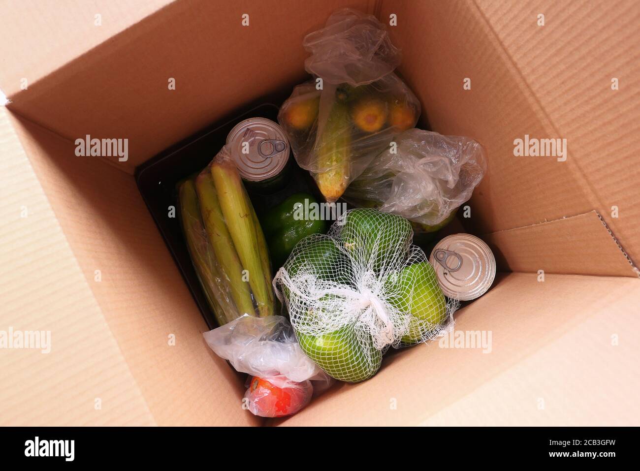 Porte de livraison des marchandises. Le préparateur de commande emballant les aliments dans des boîtes en carton. Banque D'Images