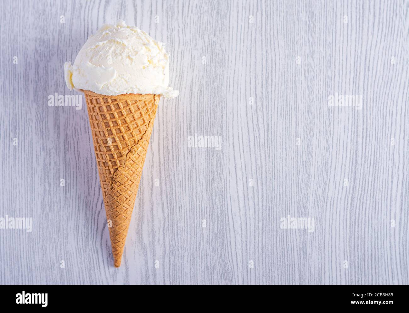 Cône de crème glacée sur fond de bois blanc. Un cône de glace de type cachets. Heure d'été Banque D'Images