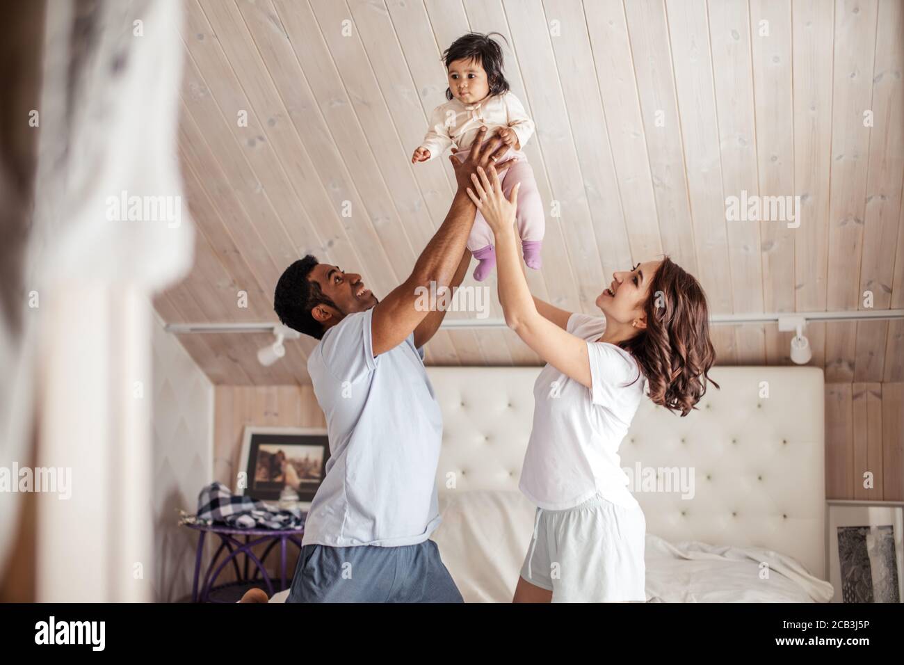 agréable mère et père joyeux tenant le bébé au-dessus de thir têtes.gros plan Banque D'Images
