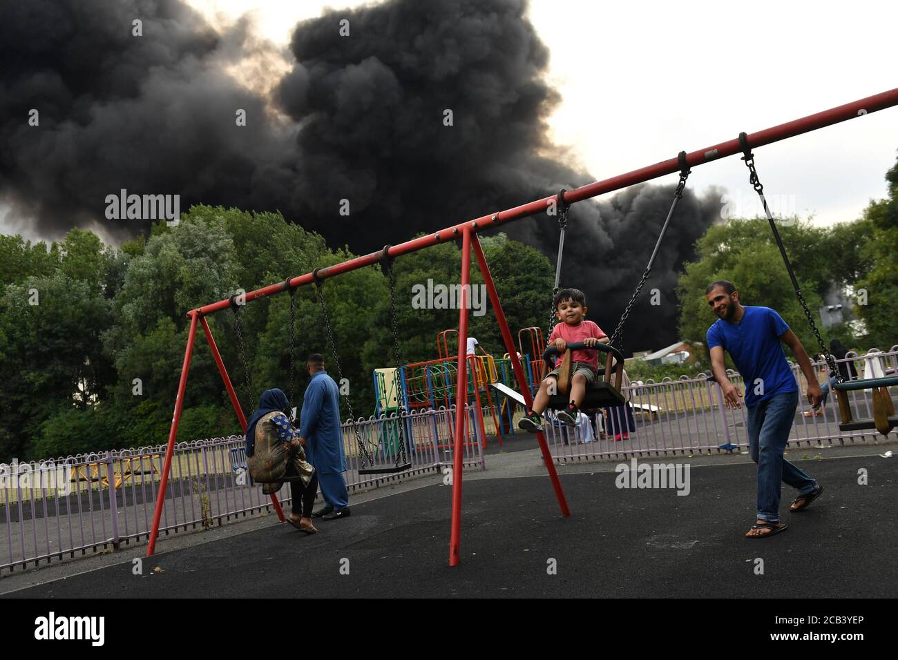 L'AUTORISATION PARENTALE A PERMIS aux personnes se trouvant dans un parc alors que de la fumée s'est enflamée dans un domaine industriel de Birmingham. Les équipes de 10 moteurs d'incendie s'attaquent à l'incendie. Banque D'Images