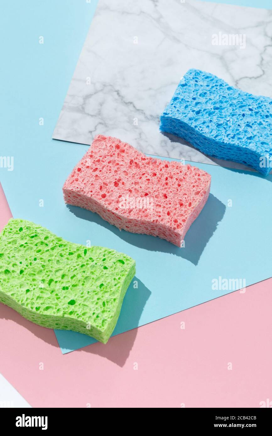 Disposition créative avec éponges pour le lavage de la vaisselle sur fond multicolore Banque D'Images