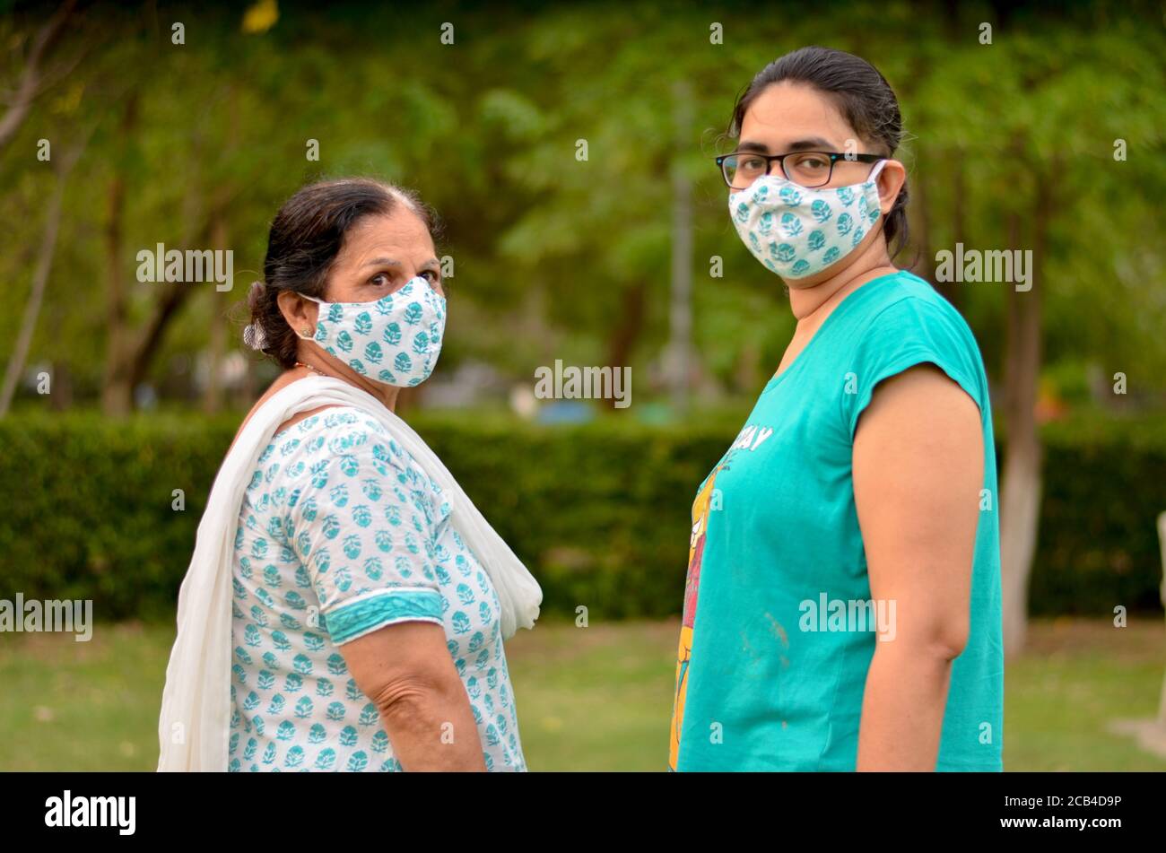Gros plan Portrait d'une femme indienne âgée et d'une jeune fille femme portant un masque en coton chirurgical assorti pour se protéger Virus Corona (COVID-19) pandem Banque D'Images