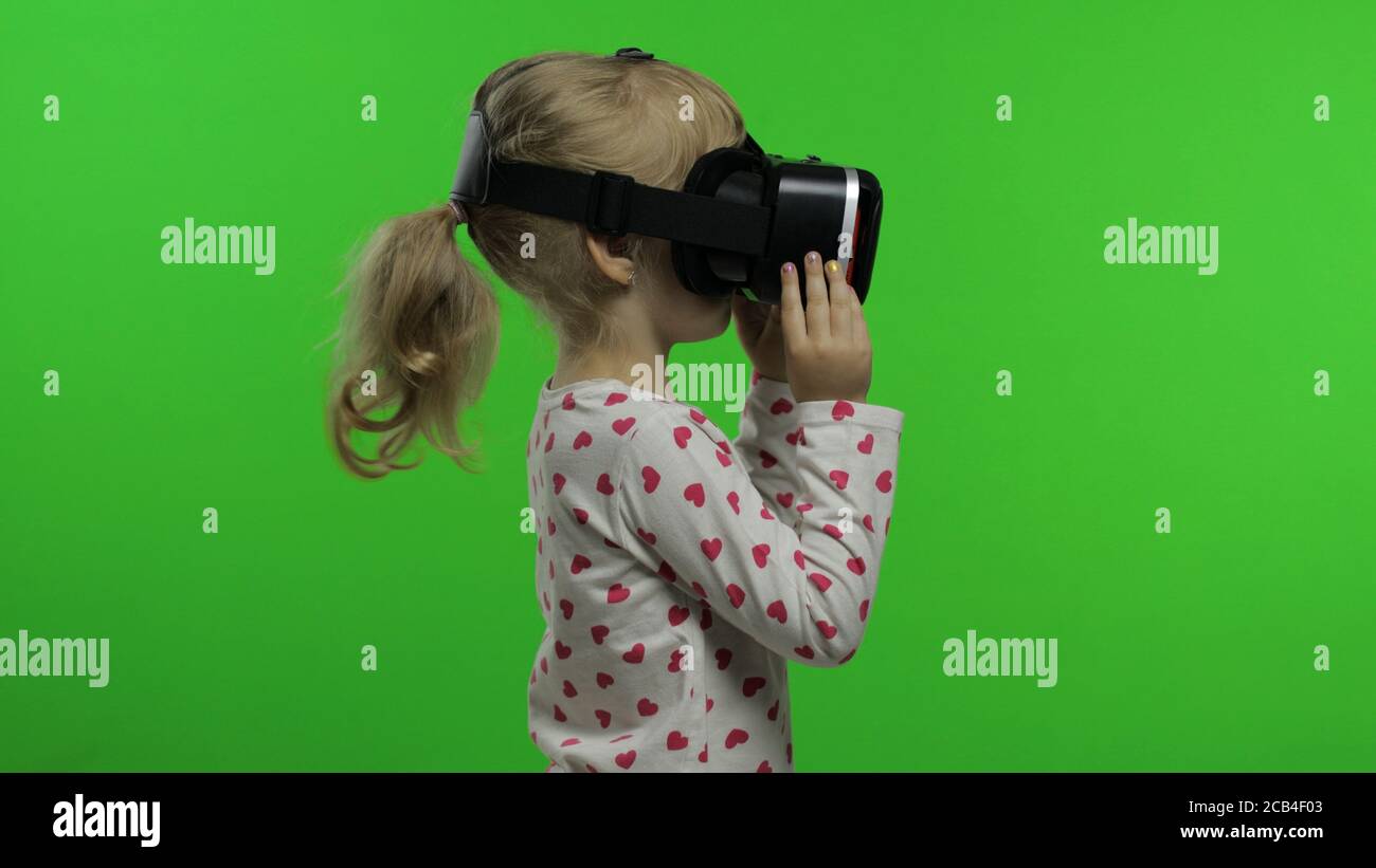 Jeune fille utilisant un casque VR pour jouer. Regarder la vidéo 3d 360 de  réalité virtuelle. Isolé sur fond vert chroma Key en studio. Technologie  future. Enfants dans des lunettes VR regardant