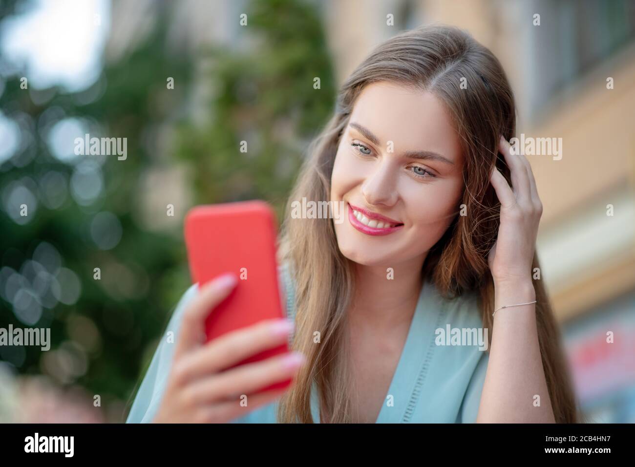 Jeune femme aux lèvres rouges, cheveux de course, de vérifier son téléphone Banque D'Images