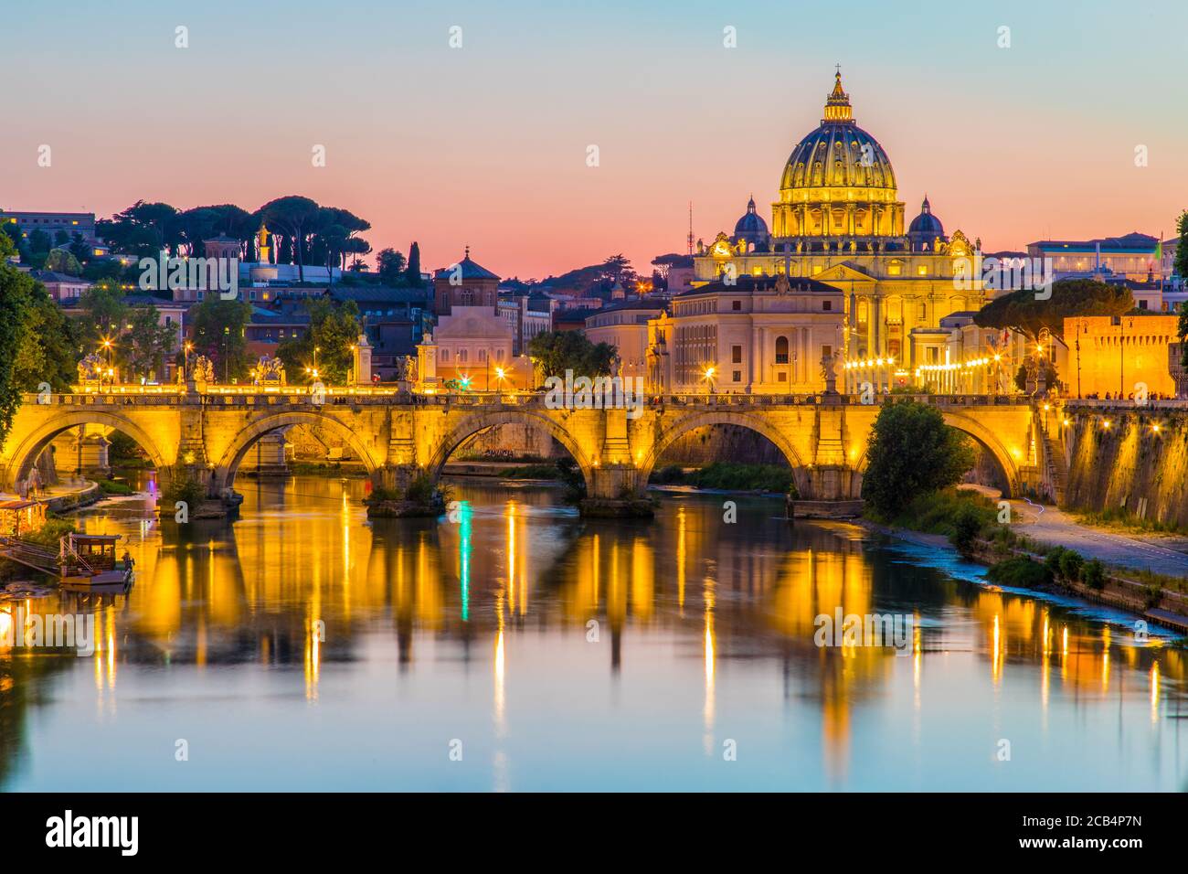 Vue sur la basilique Saint-Pierre et la Cité du Vatican au coucher du soleil le long du Tibre à Rome, en Italie Banque D'Images