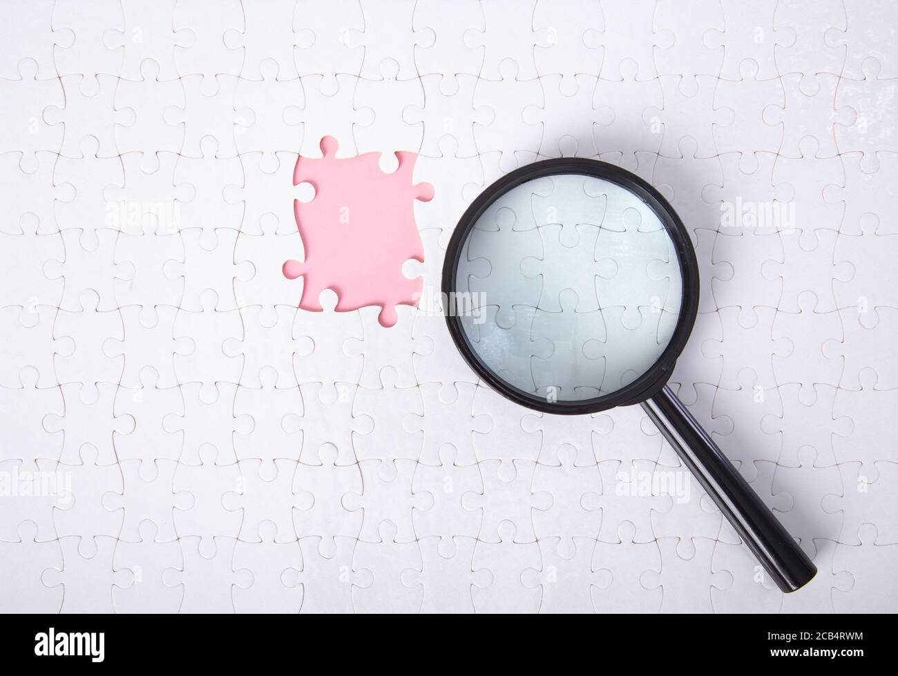 Vue de dessus gros plan d'un ensemble de pièces de puzzle avec une loupe Banque D'Images