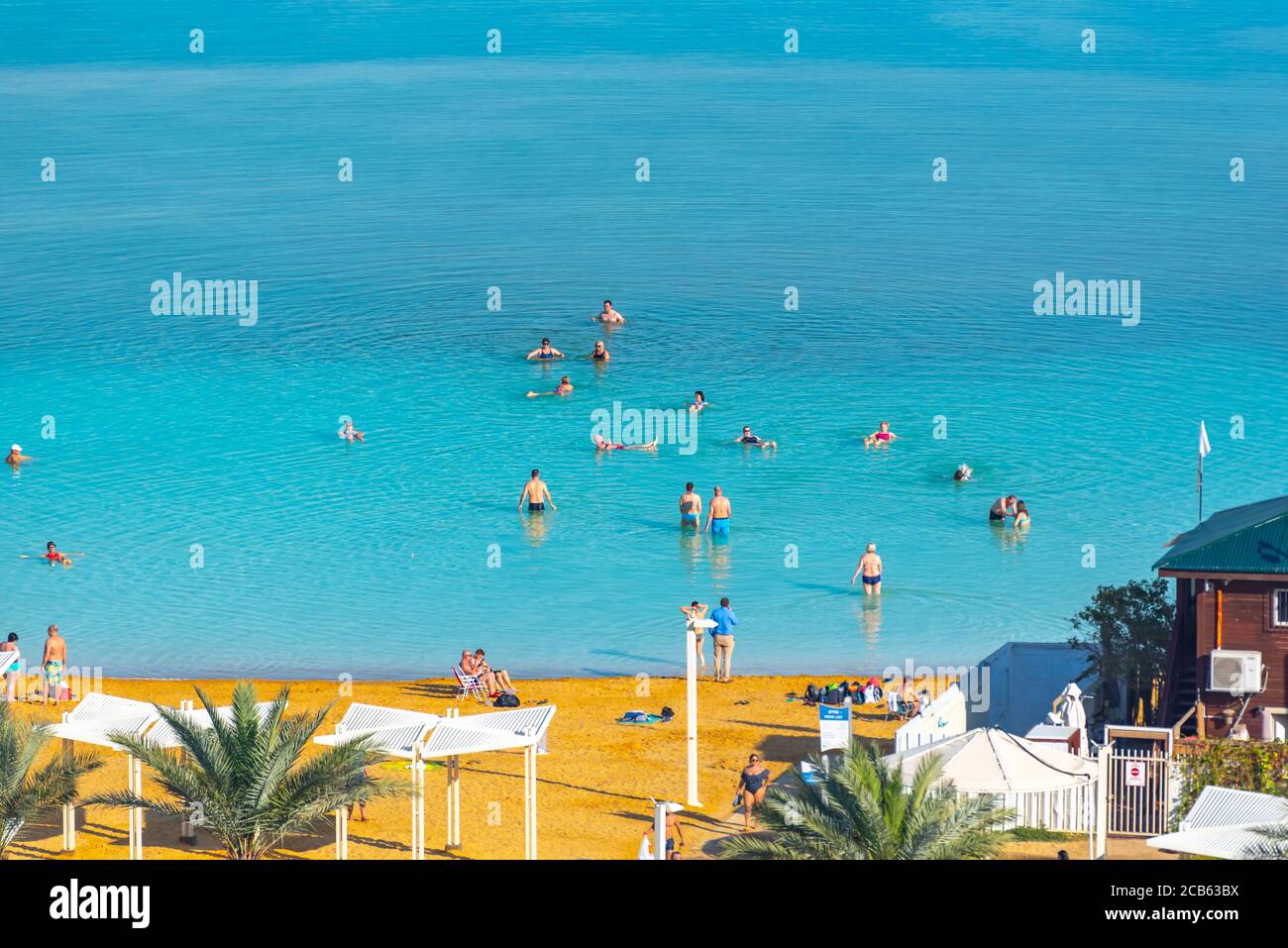 Les touristes flottent dans les eaux lourdes de la mer Morte, Israël Banque D'Images