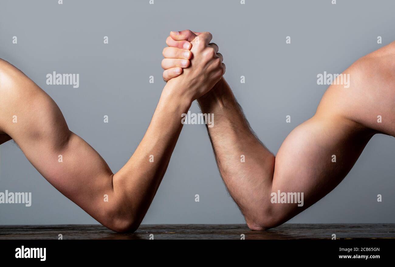 Lutte de bras. Bras d'homme fortement musclé luttant contre un homme faible et puny. Bras luttant une main mince et un gros bras fort en studio. Deux mains d'homme ont classé le bras Banque D'Images