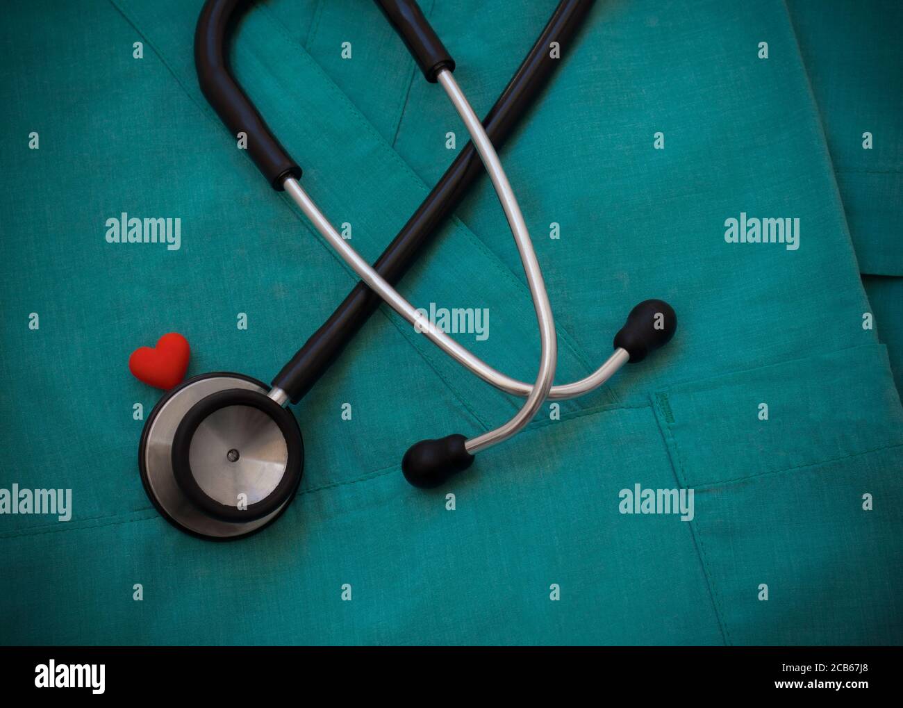 Stéthoscope et cœur rouge sur fond vert, vue de dessus. Objets médicaux.concept de cardiologie. Journée mondiale de la santé et concept de la santé. Banque D'Images