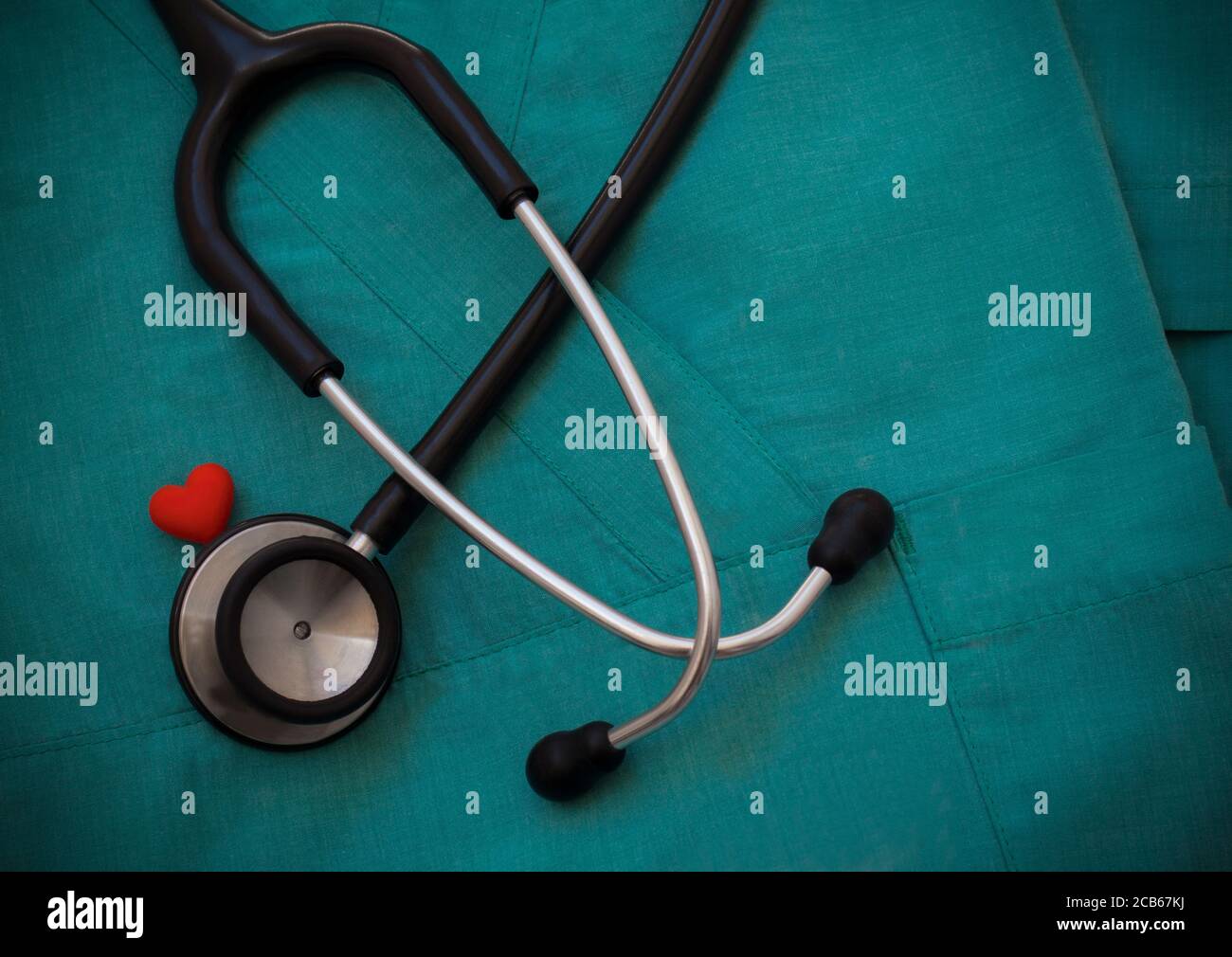 Stéthoscope et cœur rouge sur fond vert, vue de dessus. Objets médicaux.concept de cardiologie. Journée mondiale de la santé et concept de la santé. Banque D'Images