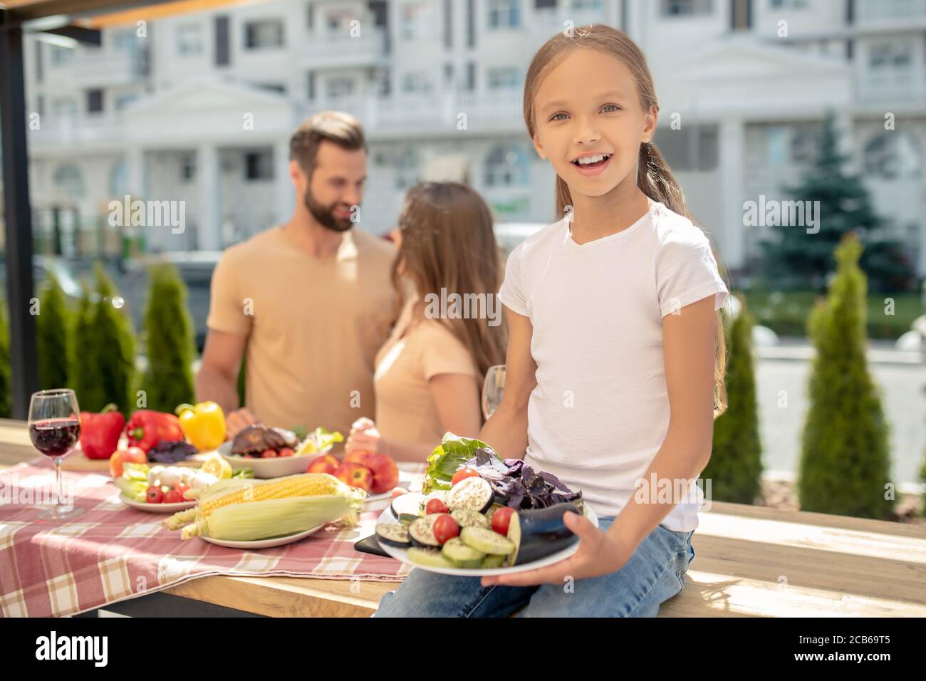 Jeune famille heureuse dînant à l'extérieur et se sentant super Banque D'Images