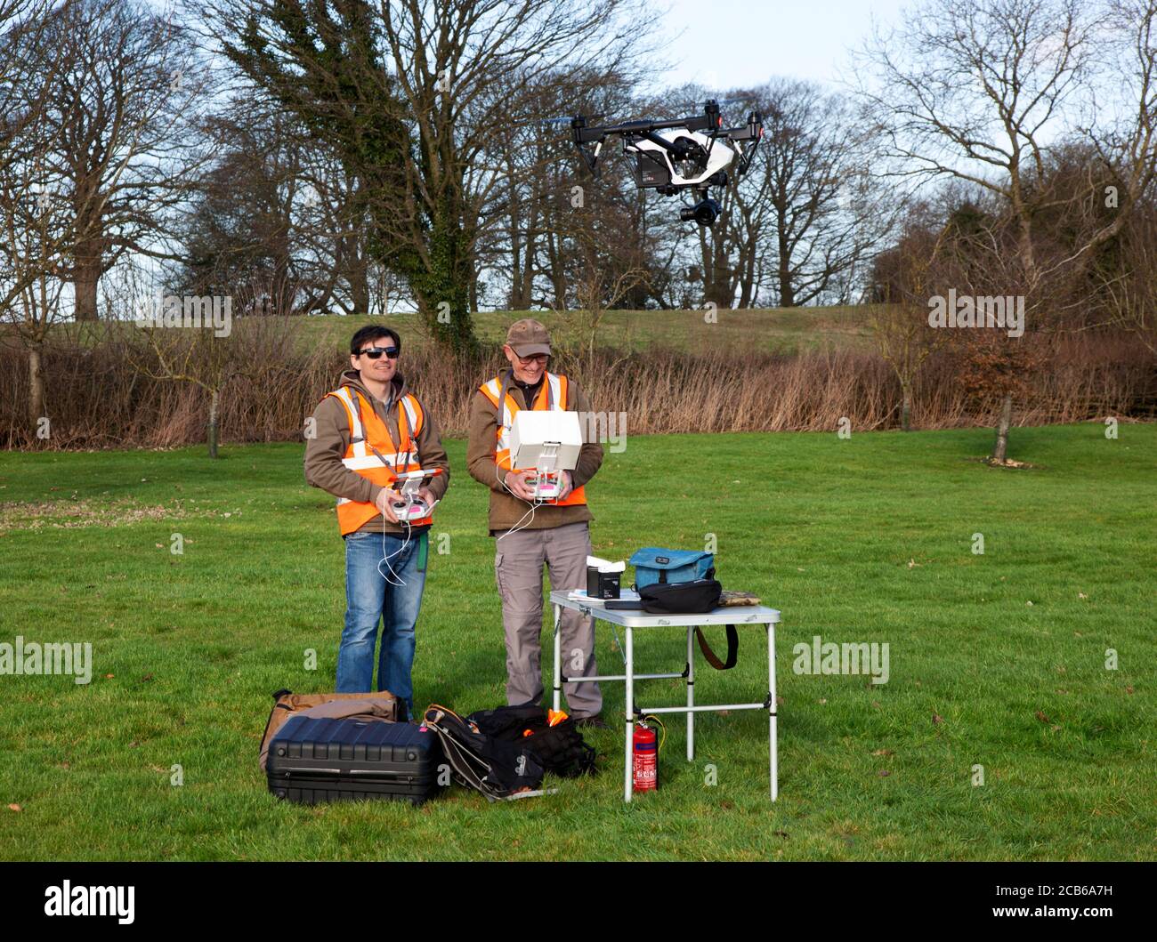 Deux photographes aiment voler un drone avec un appareil photo dedans Un grand jardin de campagne dans les Cotswolds Banque D'Images