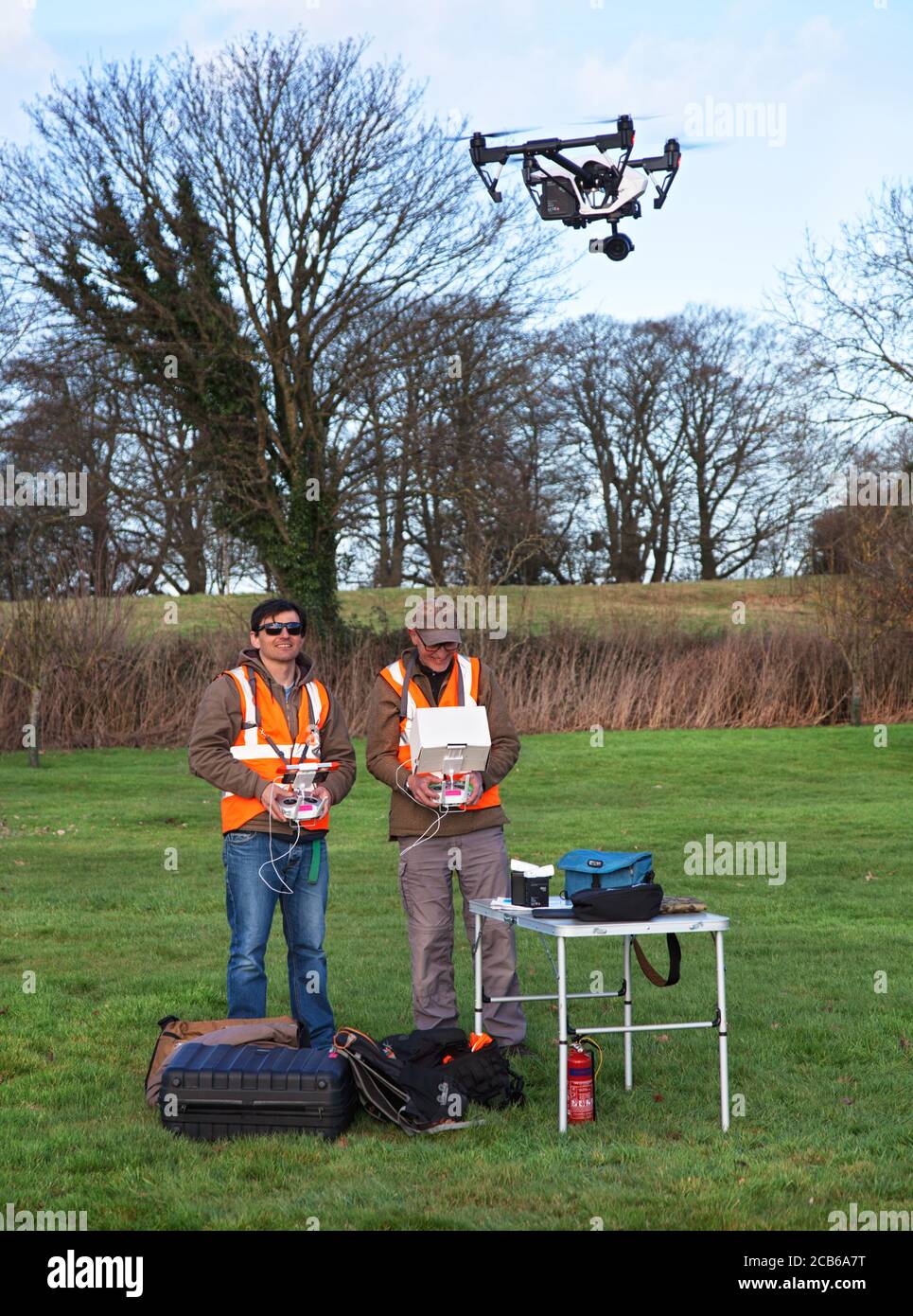 Deux photographes aiment voler un drone avec un appareil photo dedans Un grand jardin de campagne dans les Cotswolds Banque D'Images