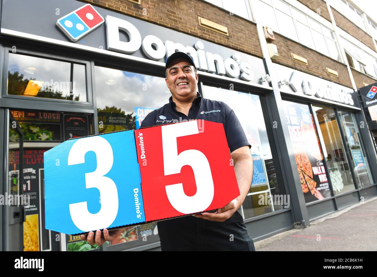 Mujahid Yasin, franchisé de Domino célèbre 35 ans de la marque au Royaume-Uni dans le premier magasin Domino de Luton Central, car Domino's Pizza Group plc publie également ses résultats du premier semestre 2020. Banque D'Images