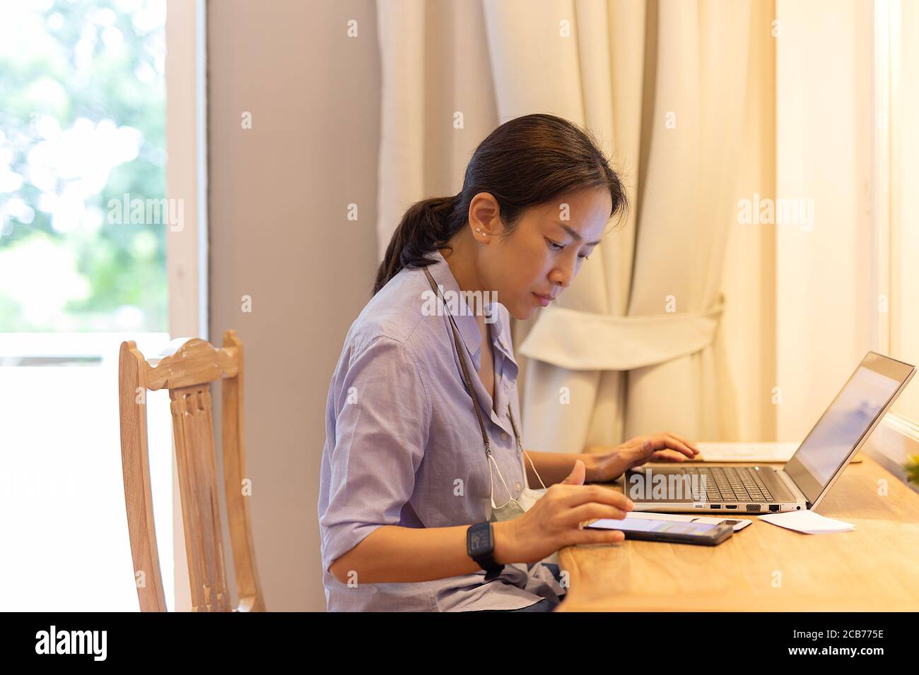 Femme travaillant sur un ordinateur portable dans la chambre d'hôtel. Banque D'Images