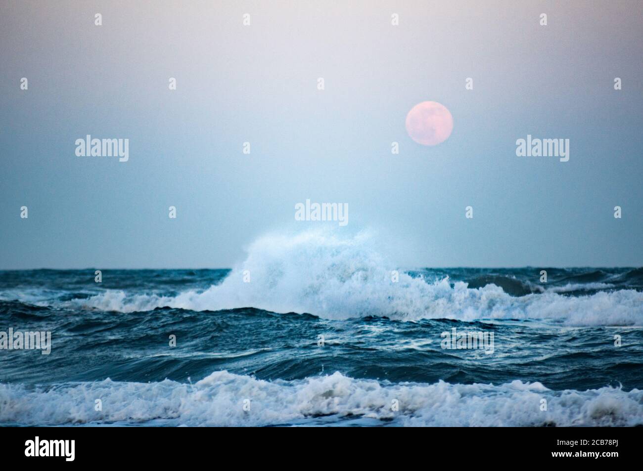 mer sauvage avec pleine lune en arrière-plan, se concentrer sur la grande vague Banque D'Images