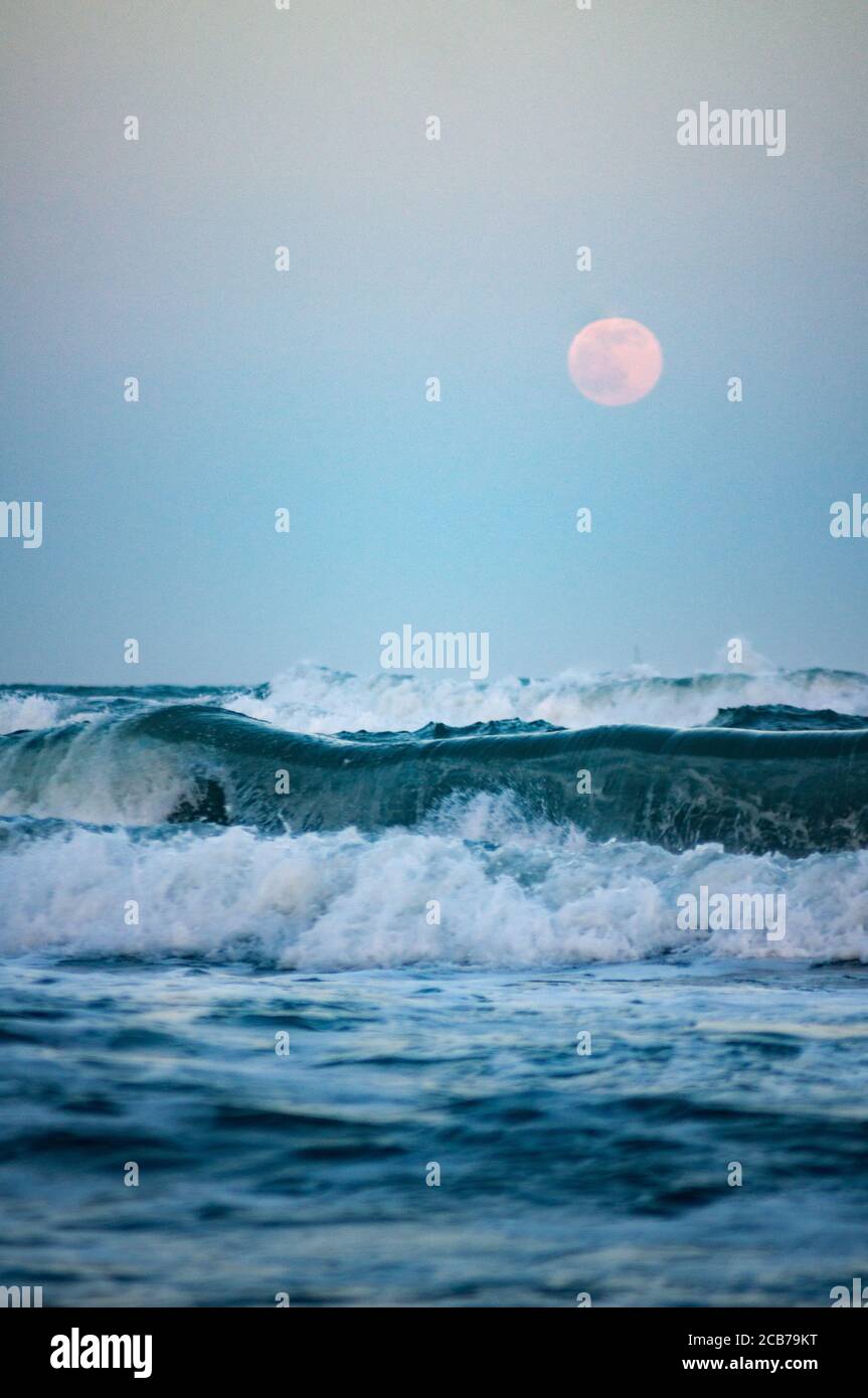 mer sauvage avec pleine lune en arrière-plan, se concentrer sur la grande vague Banque D'Images