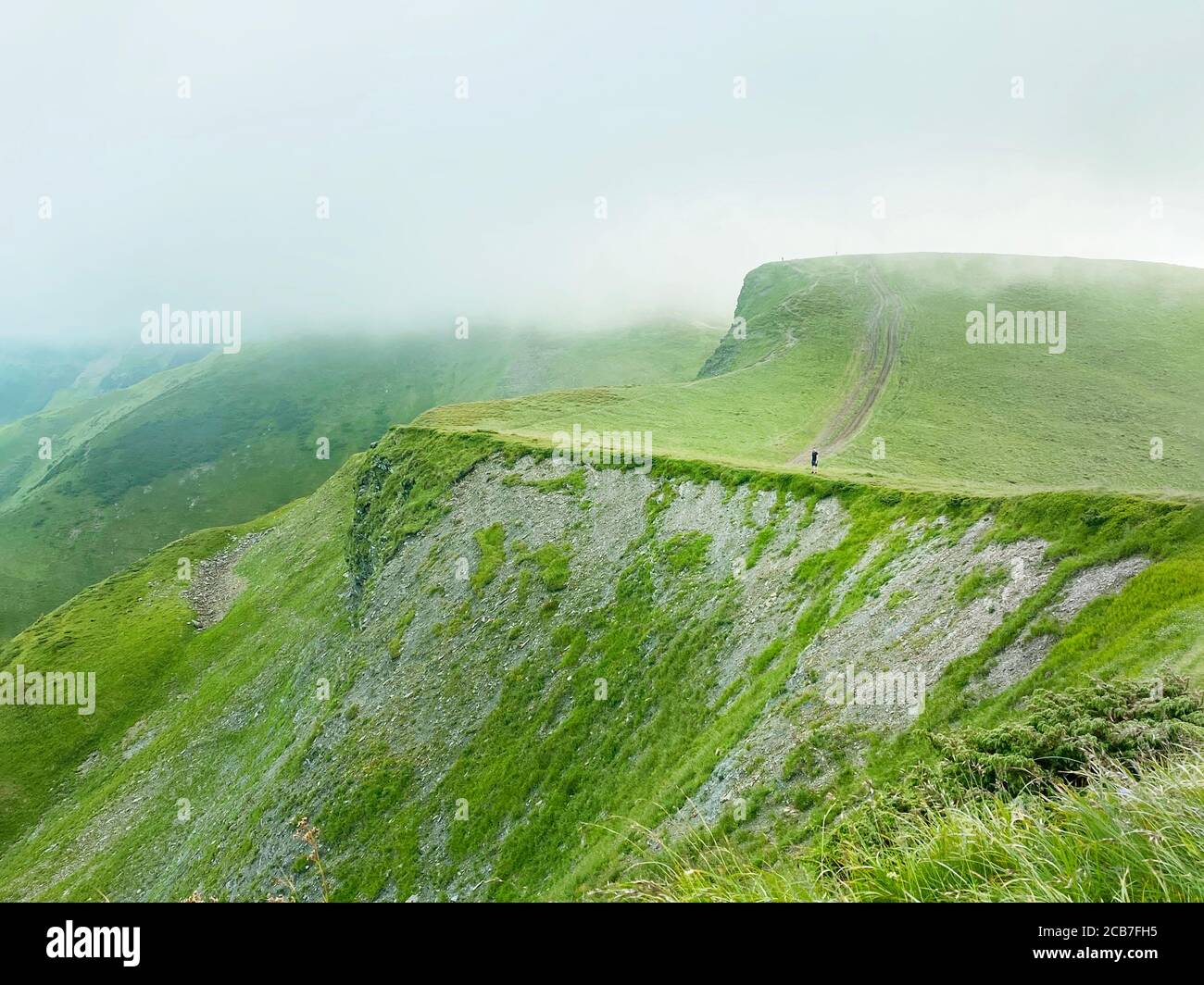 Homme marchant sur la montagne verte avec des nuages en Ukraine, Carpates, Dragobrat Banque D'Images