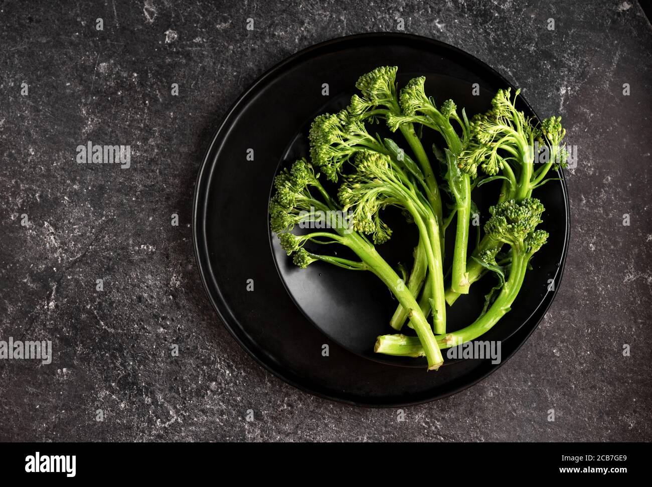 Broccolinine fraîche et verte dans un plat noir sur fond sombre Banque D'Images