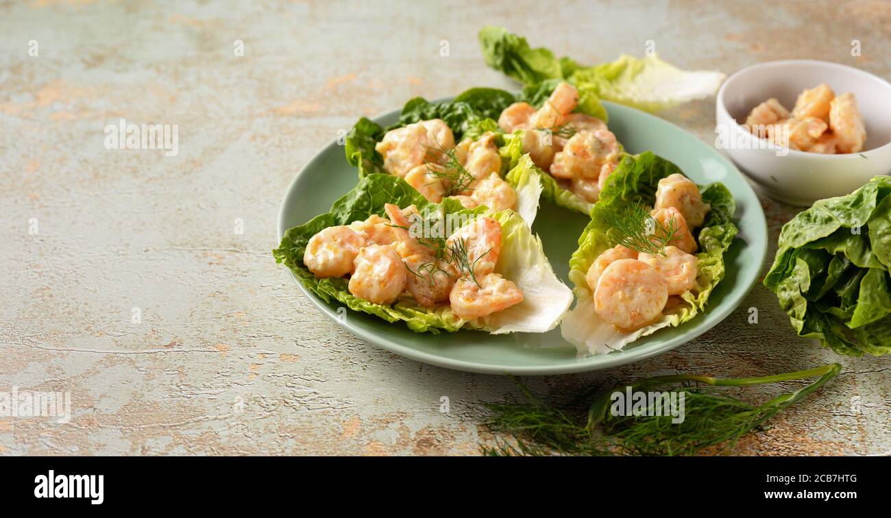 Vue latérale d'une assiette avec des feuilles de salade et des crevettes avec espace de copie Banque D'Images