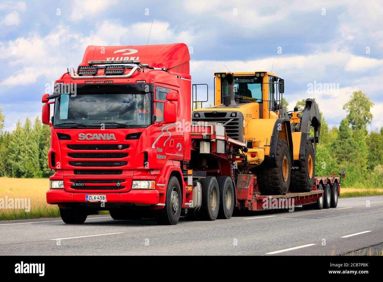 Remorque semi-remorque Scania R500 Ylijoki Kuljetus Oy transporte une chargeuse sur pneus Volvo avec des grappins à grumes le long de l'autoroute. Jokioinen, Finlande. 7 août 2020. Banque D'Images