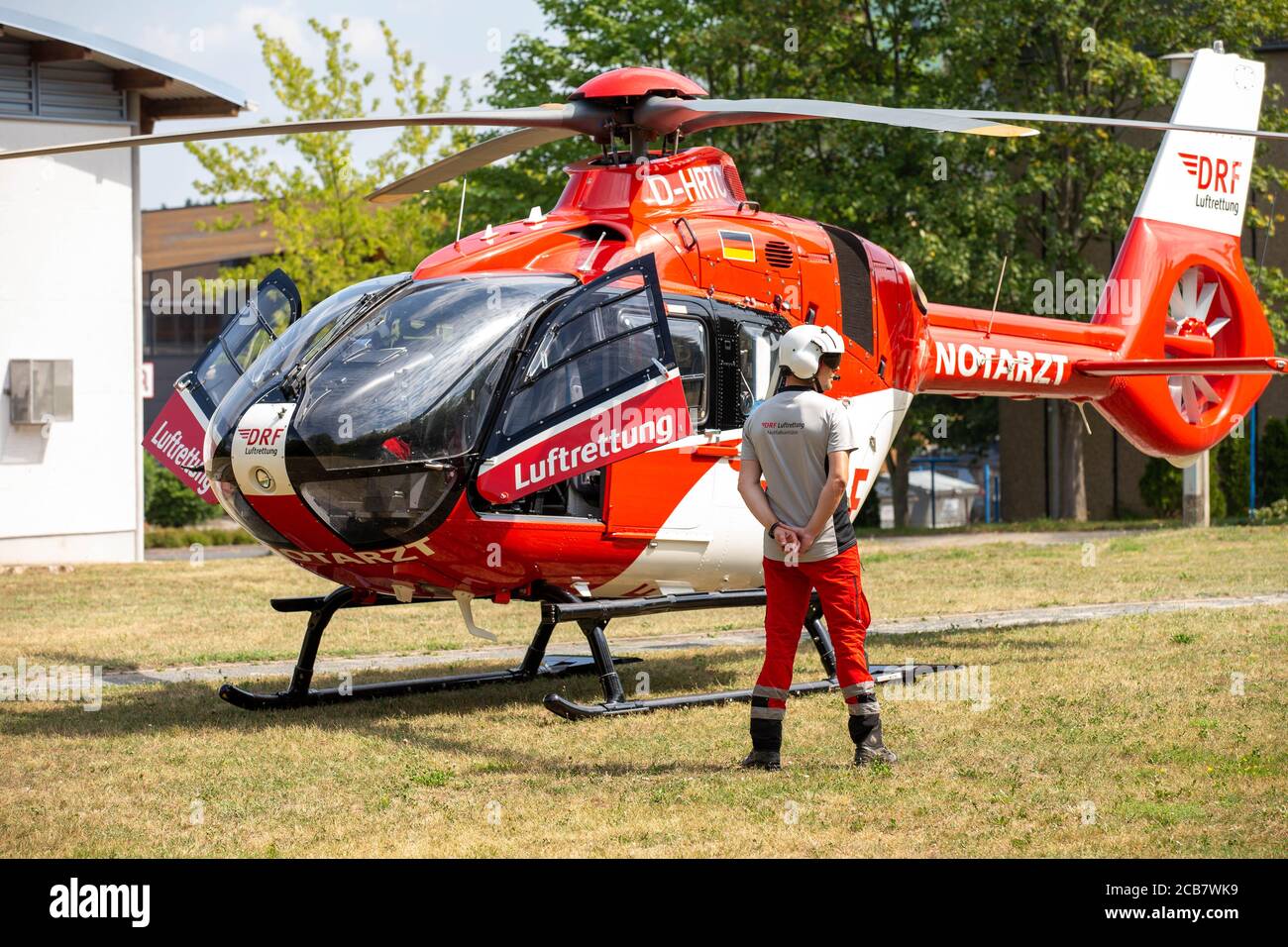 Pirna, Allemagne. 11 août 2020. Un membre d'équipage de l'équipe de sauvetage se tient sur le terrain devant l'hélicoptère et le garde. Le médecin urgentiste est en service sur un patient dans une ambulance à proximité. Credit: Daniel Schäfer/dpa-Zentralbild/ZB/dpa/Alay Live News Banque D'Images