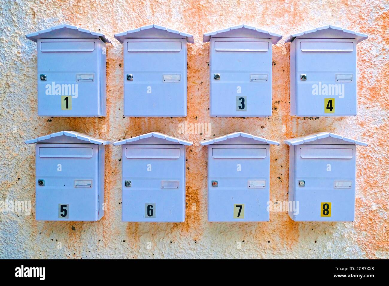 Huit boîtes de lettres sur un mur, en attente d'un courrier d'amour d'escargot lettre. Banque D'Images