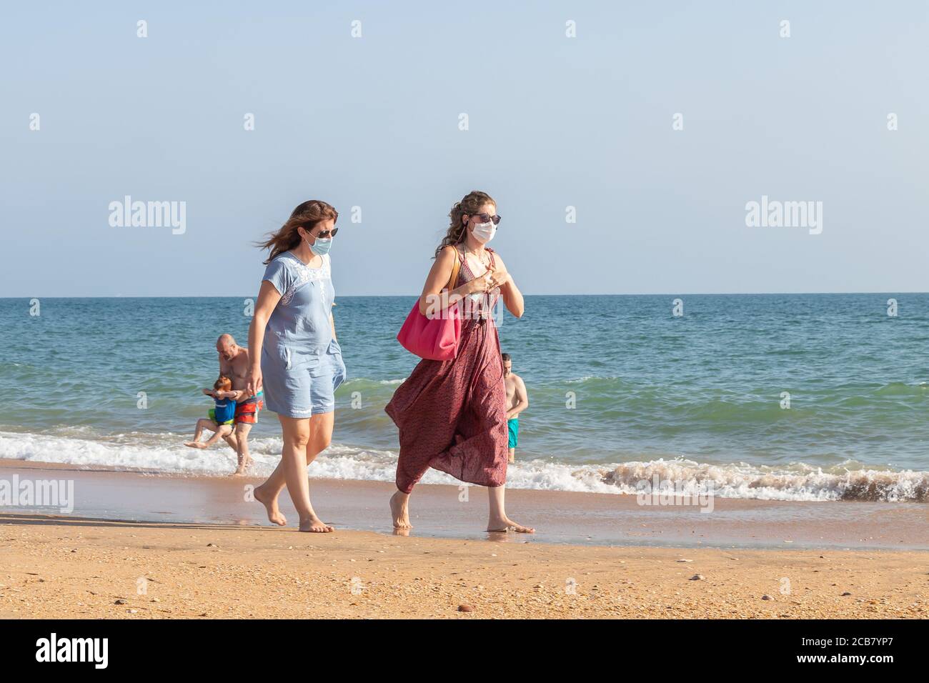 Punta Umbria, Huelva, Espagne - 7 août 2020 : deux femmes marchant sur la plage portant des masques protecteurs ou médicaux. Nouvelle normale en Espagne avec social Banque D'Images