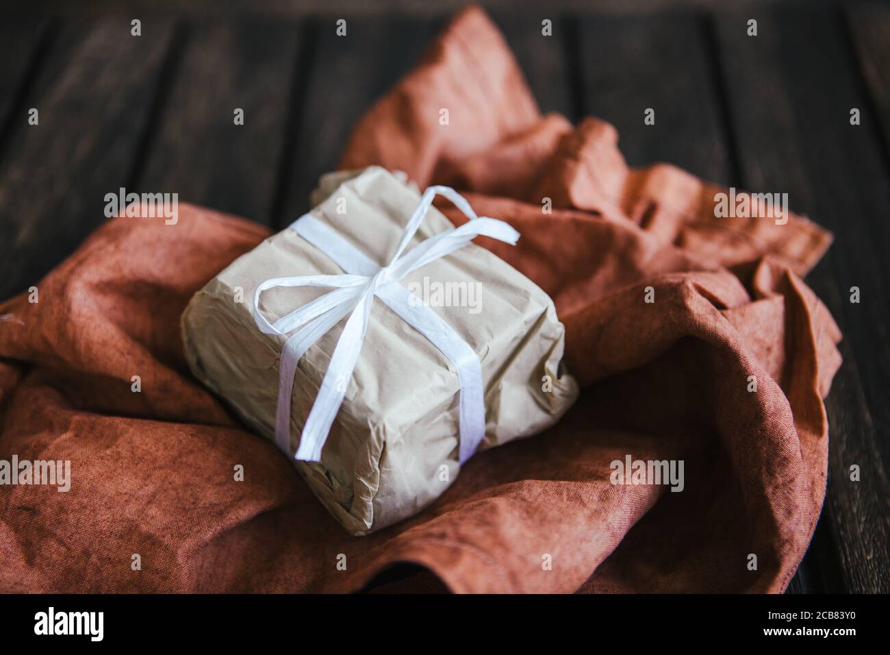 Cadeau emballé dans du papier brun sur un morceau de tissu Banque D'Images