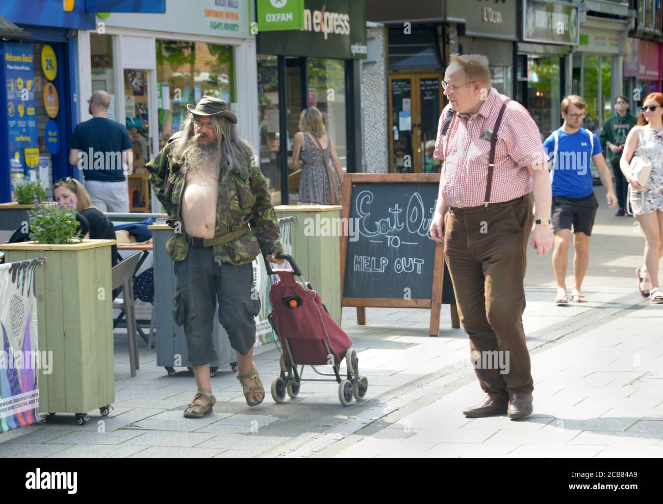 Un vieil homme plein de disais à la sortie de ses courses, avec sa chemise ouverte. Banque D'Images